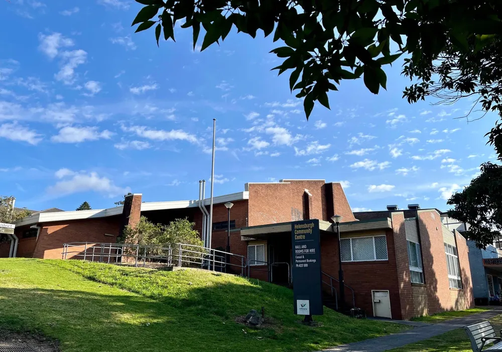 Helensburgh Community Hall at 26 Walker Street, with its brick facade, access ramp and grassy foreground.